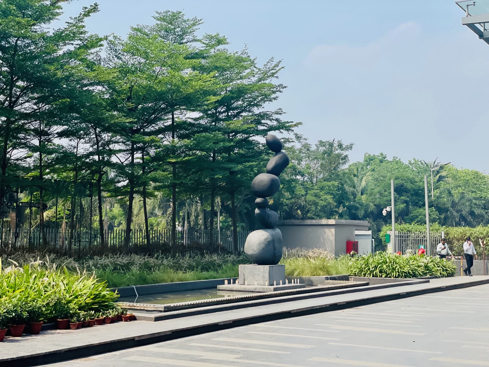 Stacked sculptural forms beside the planted arrival approach at Biowonder, Kolkata